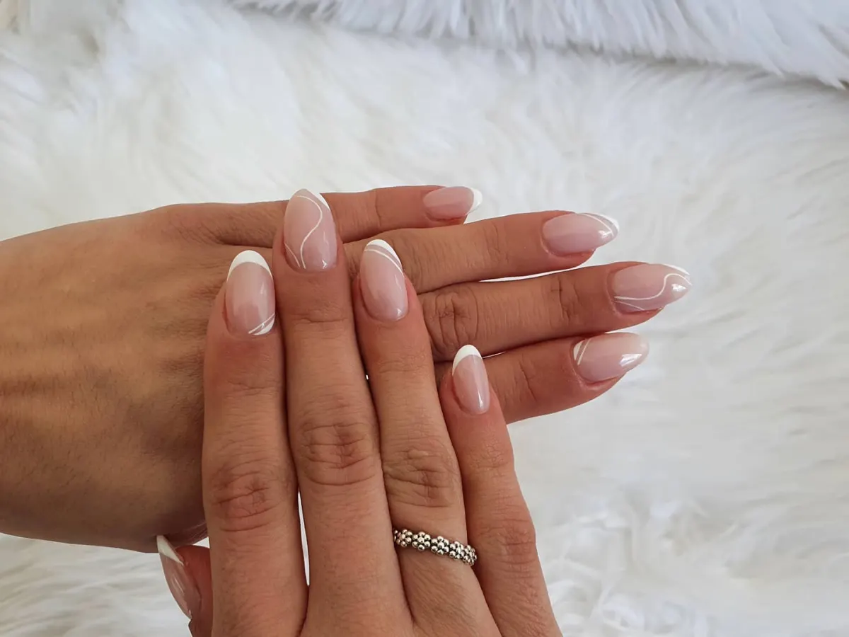 Mãos com unhas em francesa branca, feitas no salão Catarina Pinho